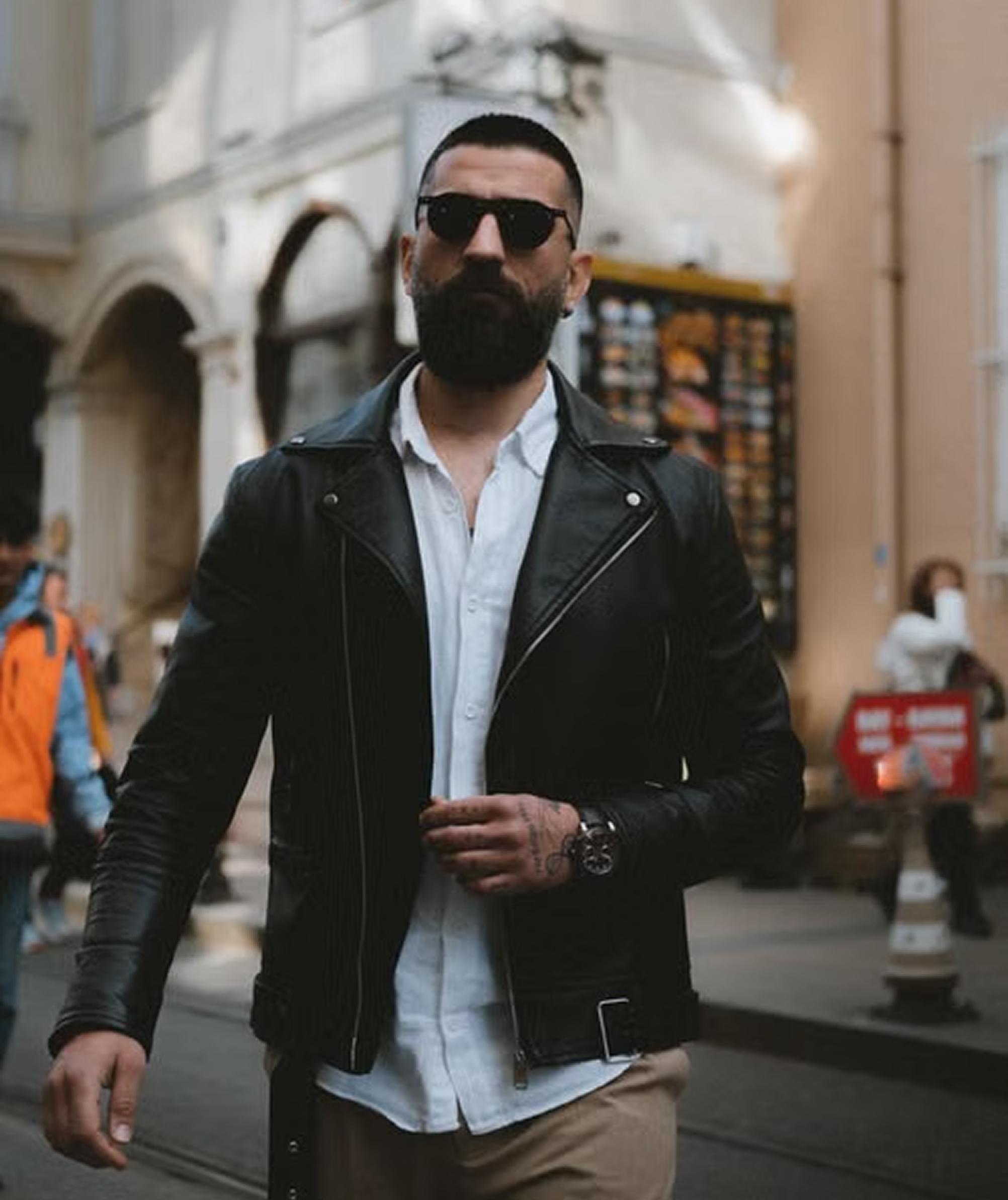 Man in a leather jacket walking through the city